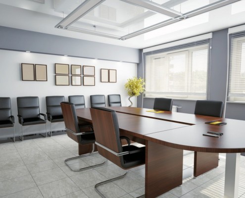 A conference room with a brown table and black chairs